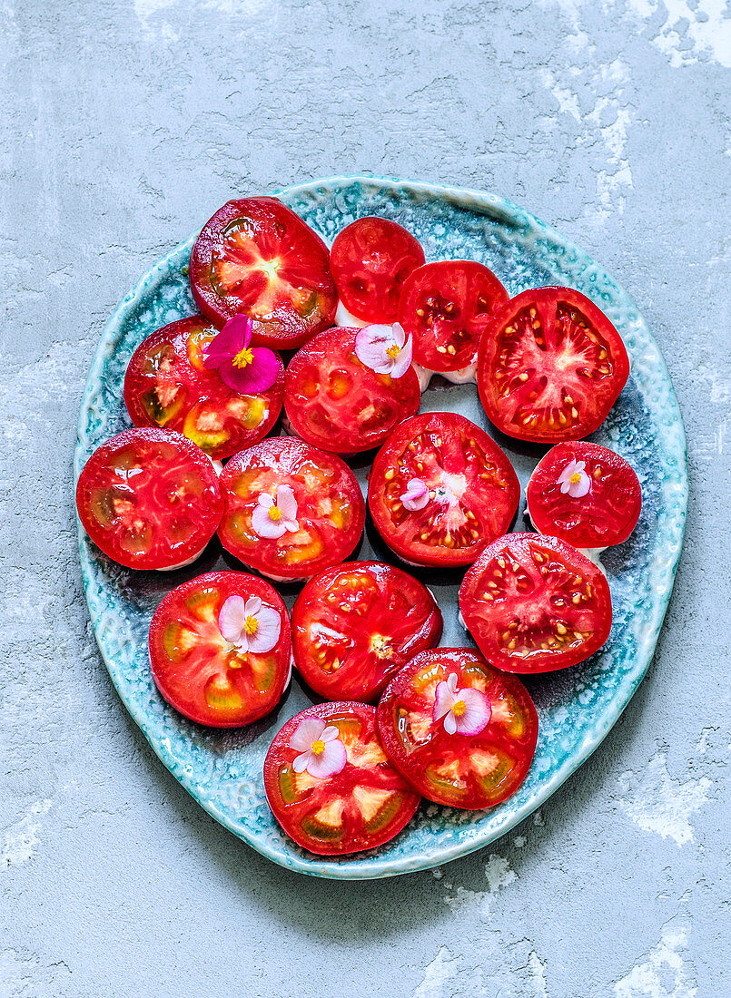 Tomatoes with edible flowers on a blue plate