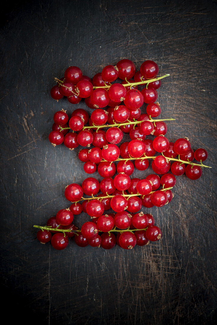 Rote Johannisbeeren auf dunkler Holzfläche