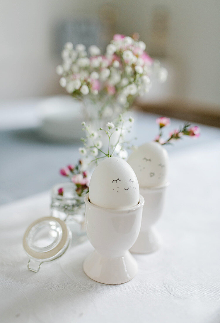 Easter eggs with faces in egg cups