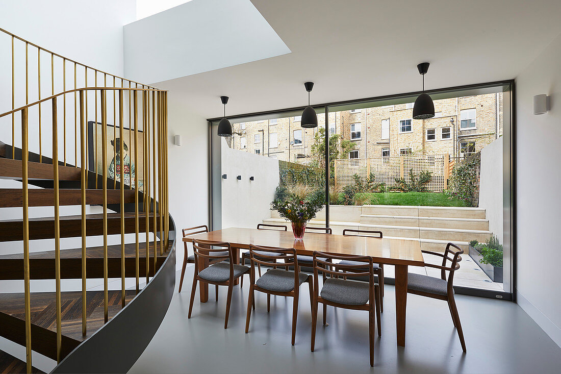 Minimalist dining room with view of garden through glass wall