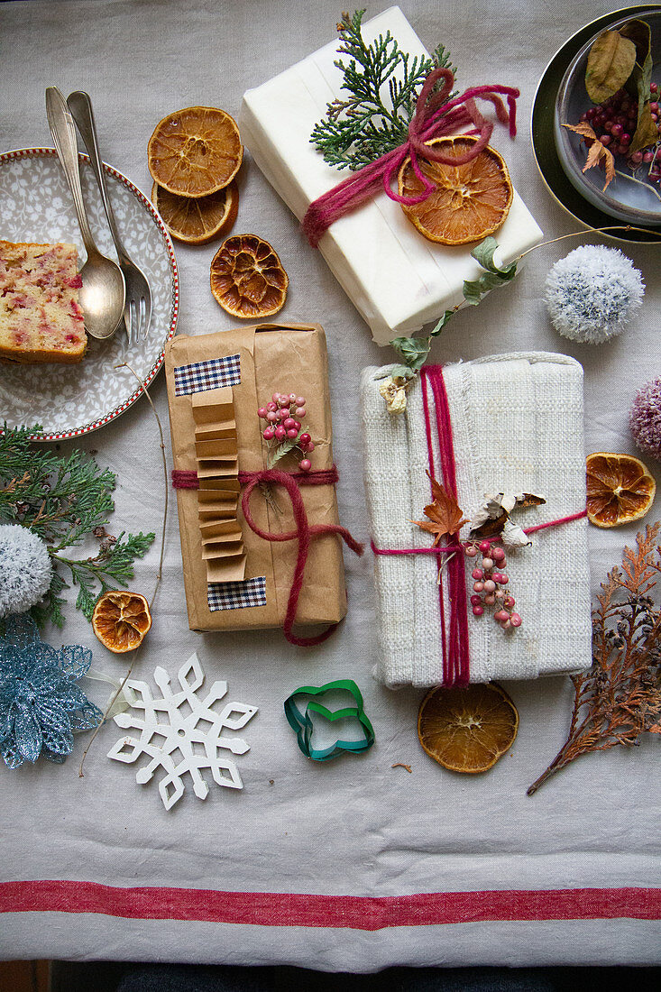 Geschenkpäckchen zwischen Kuchen und Weihnachtsdekoration