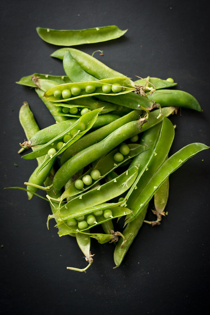 Fresh pea pods on a black background