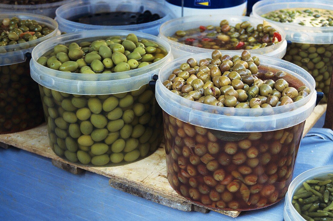 Verschieden eingelegte Oliven im Plastikschalen auf dem Markt