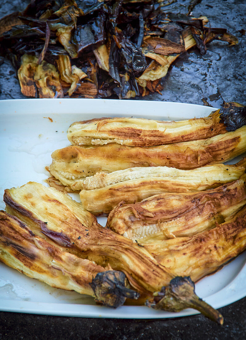 Grilled, skinned aubergines on a plate