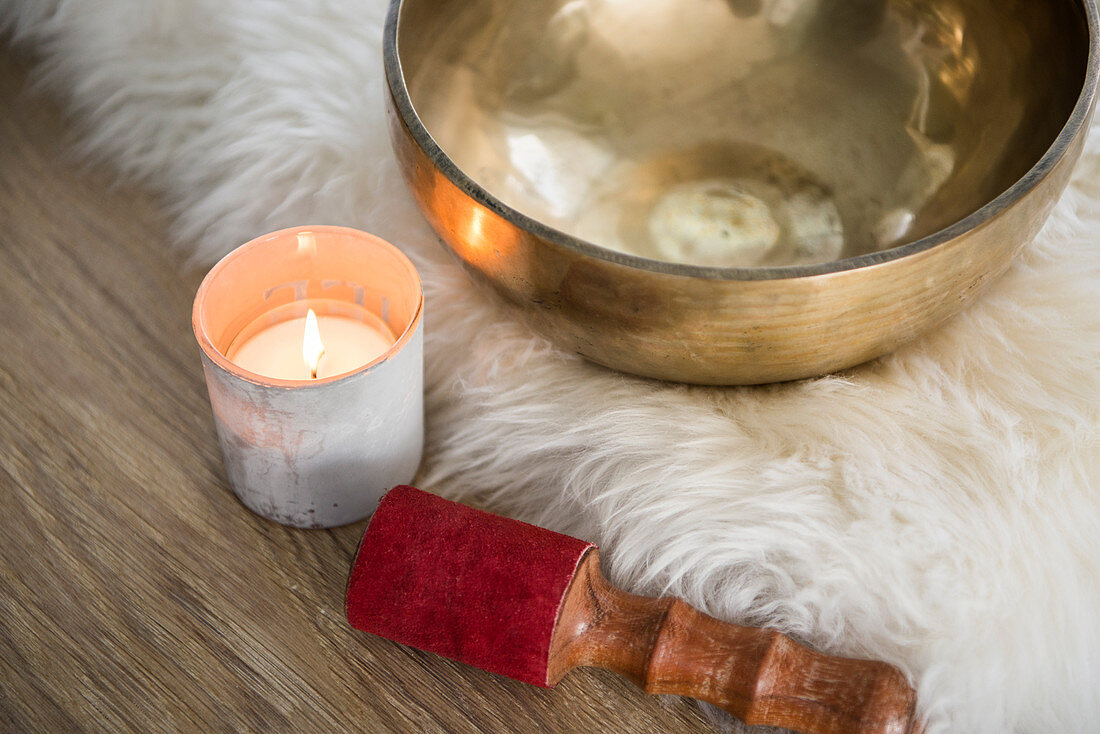 Singing bowl and tealight on fur rug