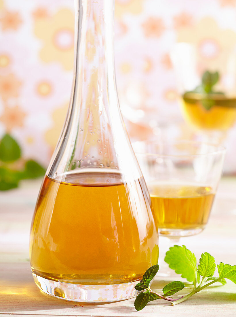 Homemade spiced herbed liqueur with peppermint and lemon balm