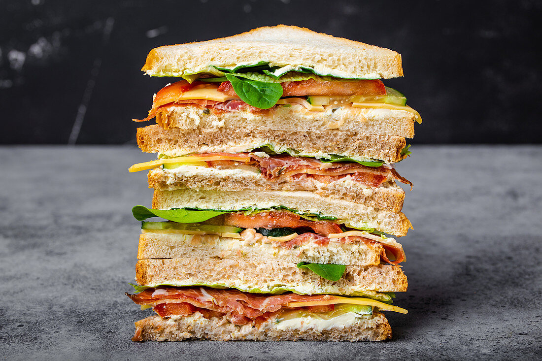 Sandwich with cheese, ham, prosciutto, fresh lettuce, tomatoes and cucumbers