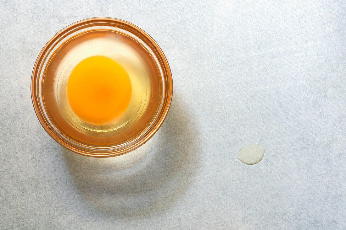 A raw egg in a small glass dish