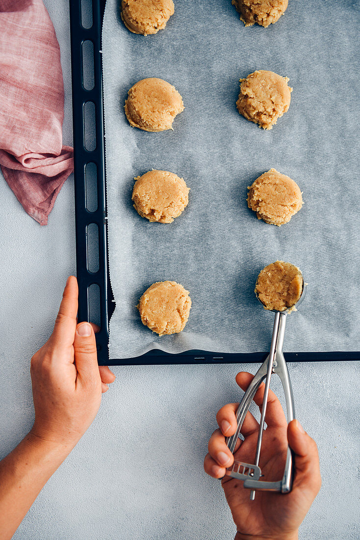 Erdnussbutter-Cookies zubereiten: Teighäufchen mit Eiskugelformer auf Backblech setzen