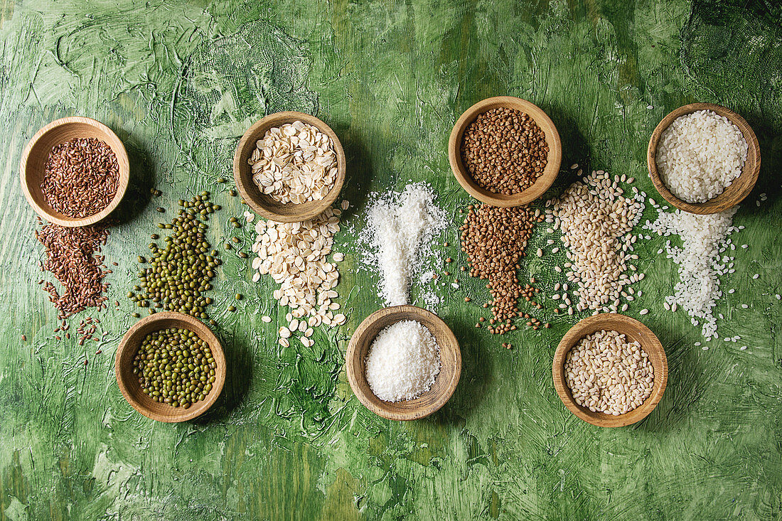 Variety of raw uncooked grains superfood cereal linen seeds, sesame, mung bean, wheat, buckwheat, oatmeal, coconut and rice