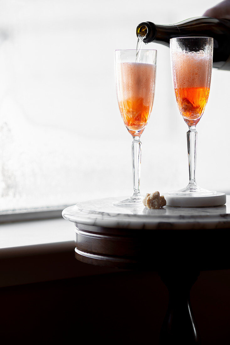 Champagnercocktail wird in Gläser gegossen