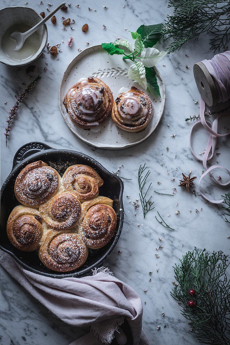 Frisch gebackene Zimtschnecken mit Puderzucker und Zuckerguss