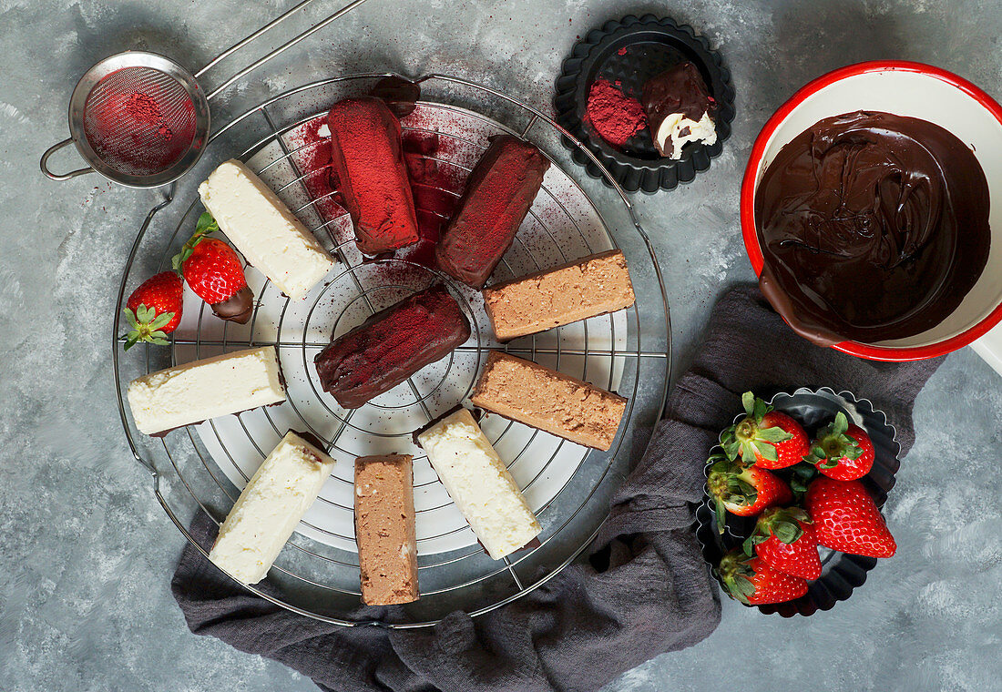 Various small chocolates and cheesecakes with strawberries
