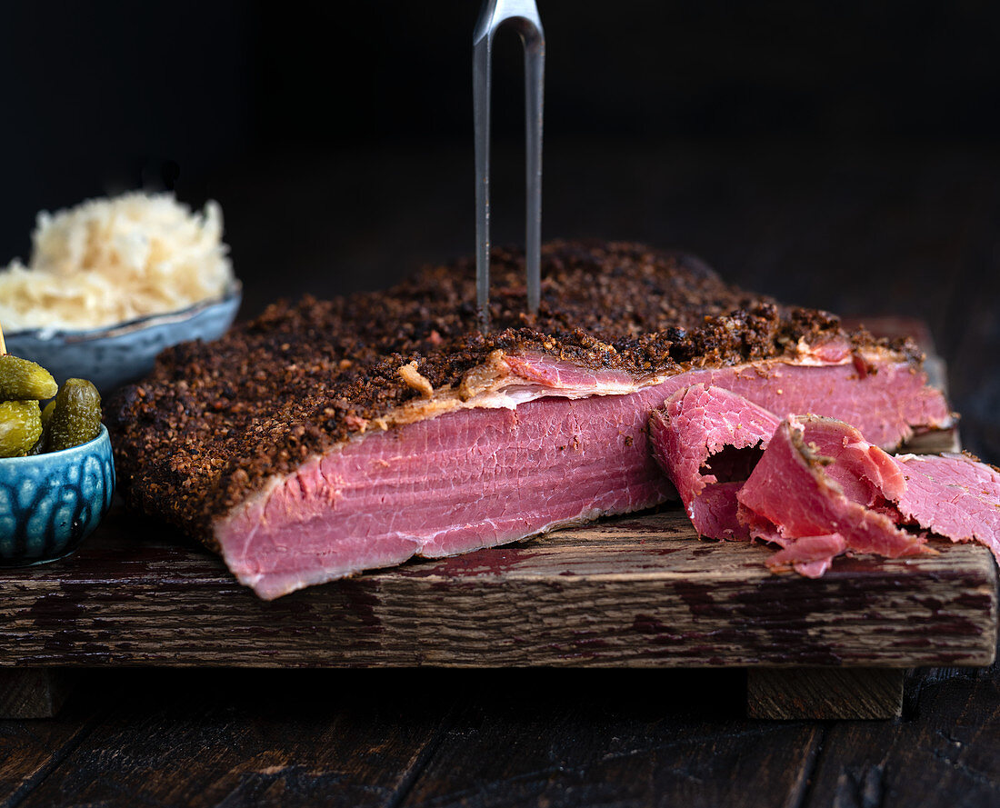 Pastrami auf Schneidebrett mit Fleischgabel