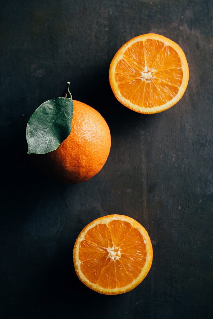 Orangen, ganz und halbiert