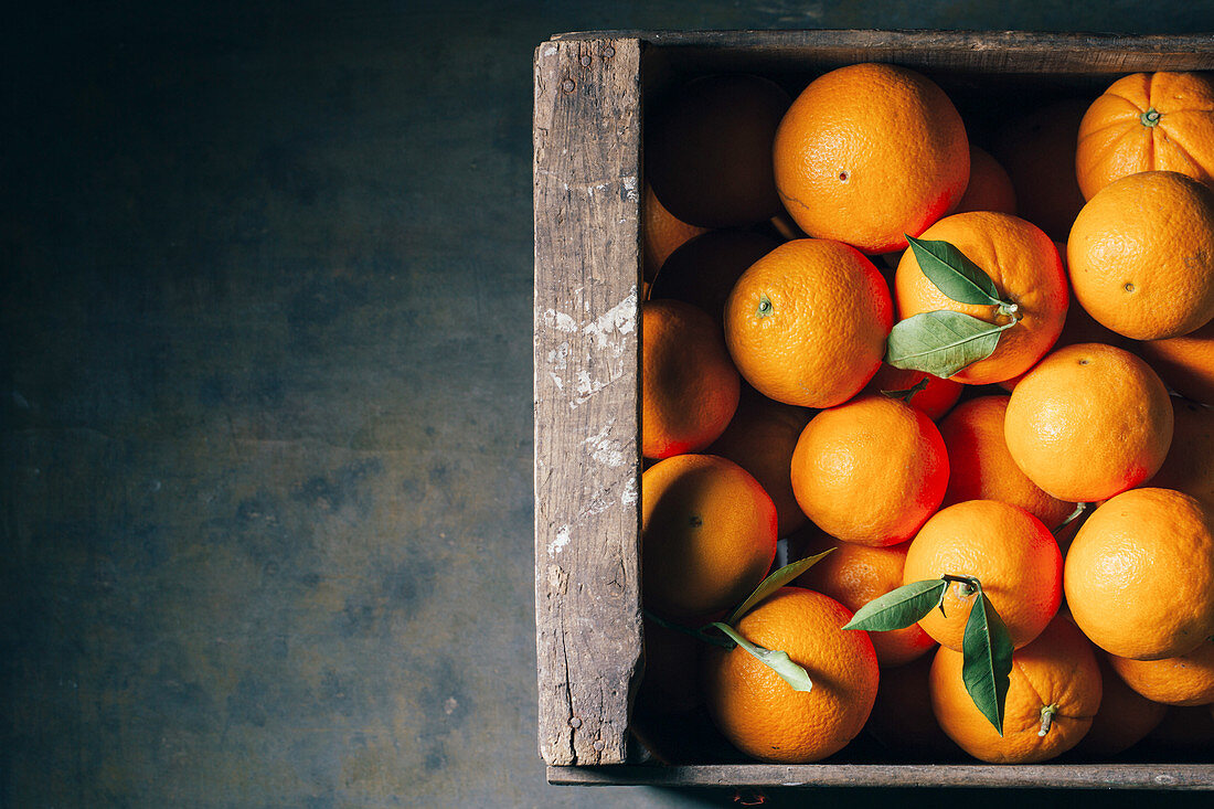 Fresh oranges in an old wooden box