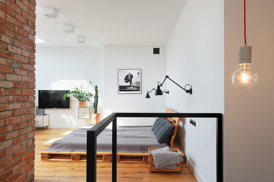 Futon in loft-style interior with exposed brickwork