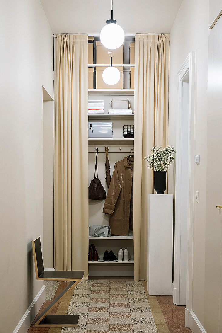 Floor-to-ceiling wardrobe behind beige curtains in hallway