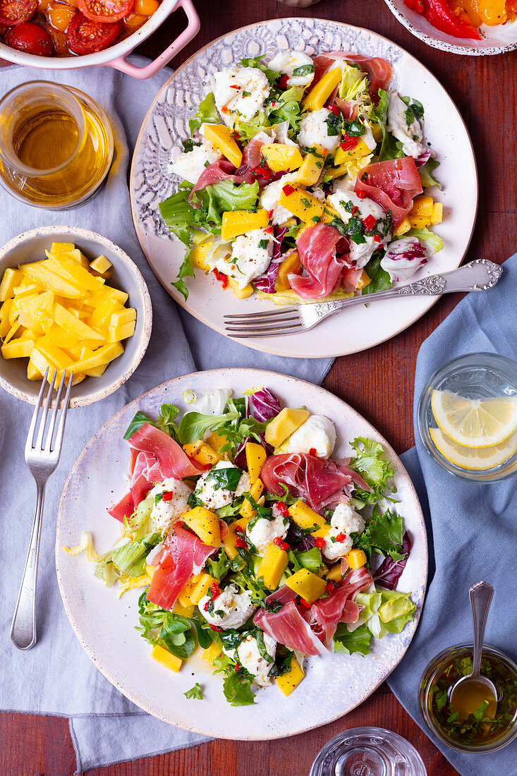 Salad with mozzarella, prosciutto and mango plus chili dressing