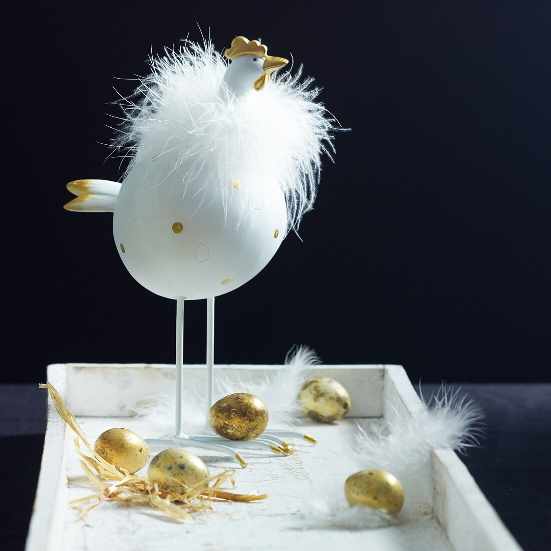 Chicken ornament, golden effs and feathers on white tray