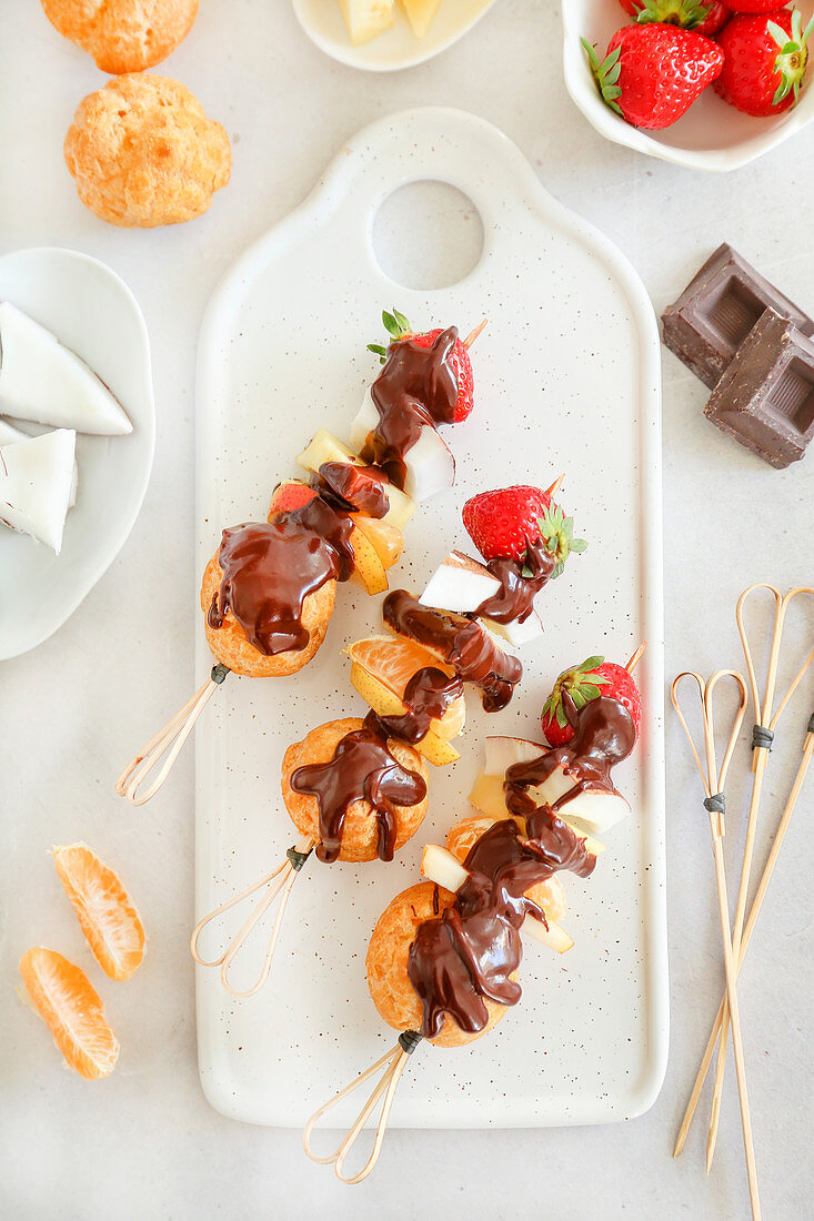 Fruit skewers cream puffs and chocolate sauce
