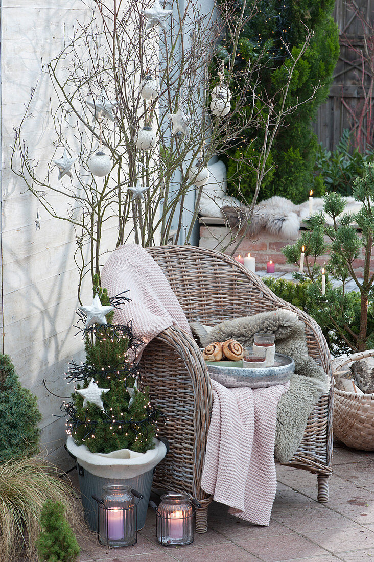 Christmas terrace with decorated sugar loaf spruce and wicker chair