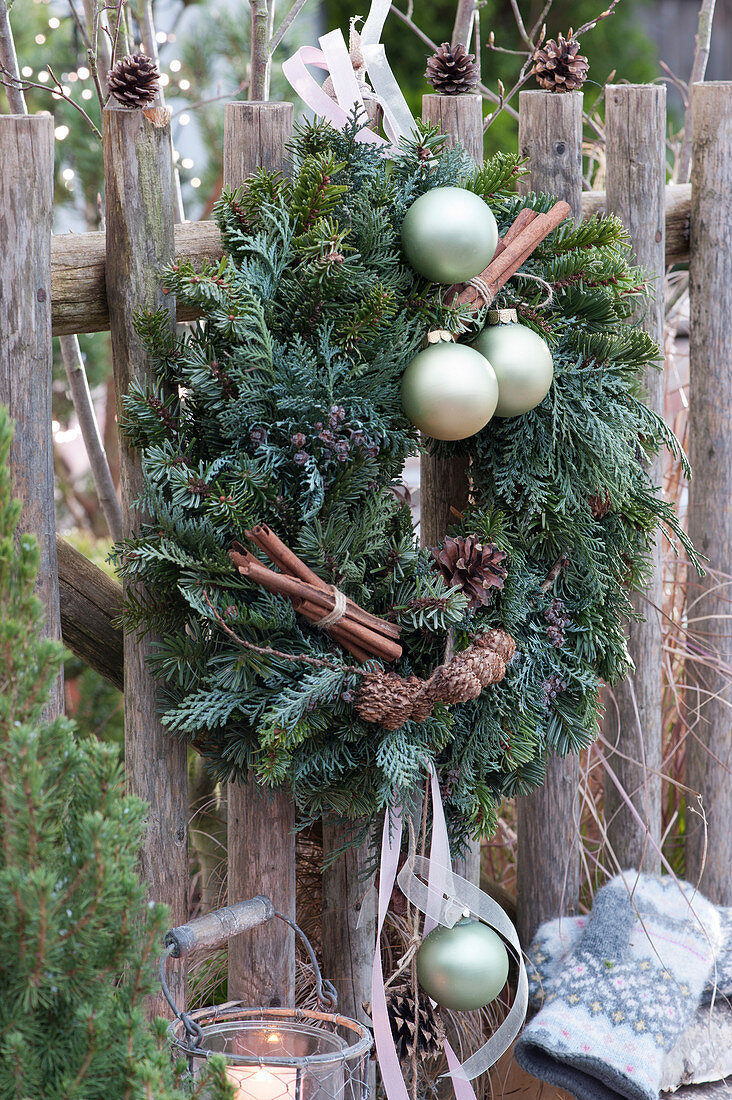 Weihnachtlich geschmückter Kranz am Gartenzaun