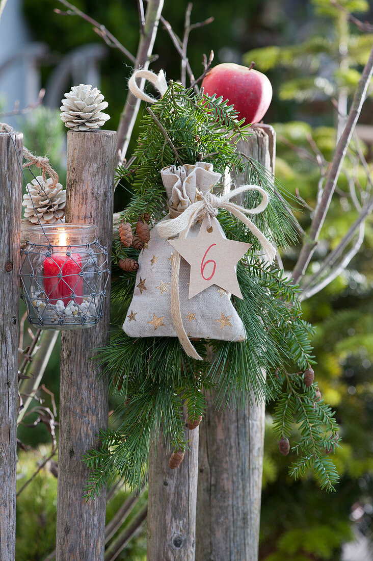 Advent- container on the garden fence with bag and numbered star