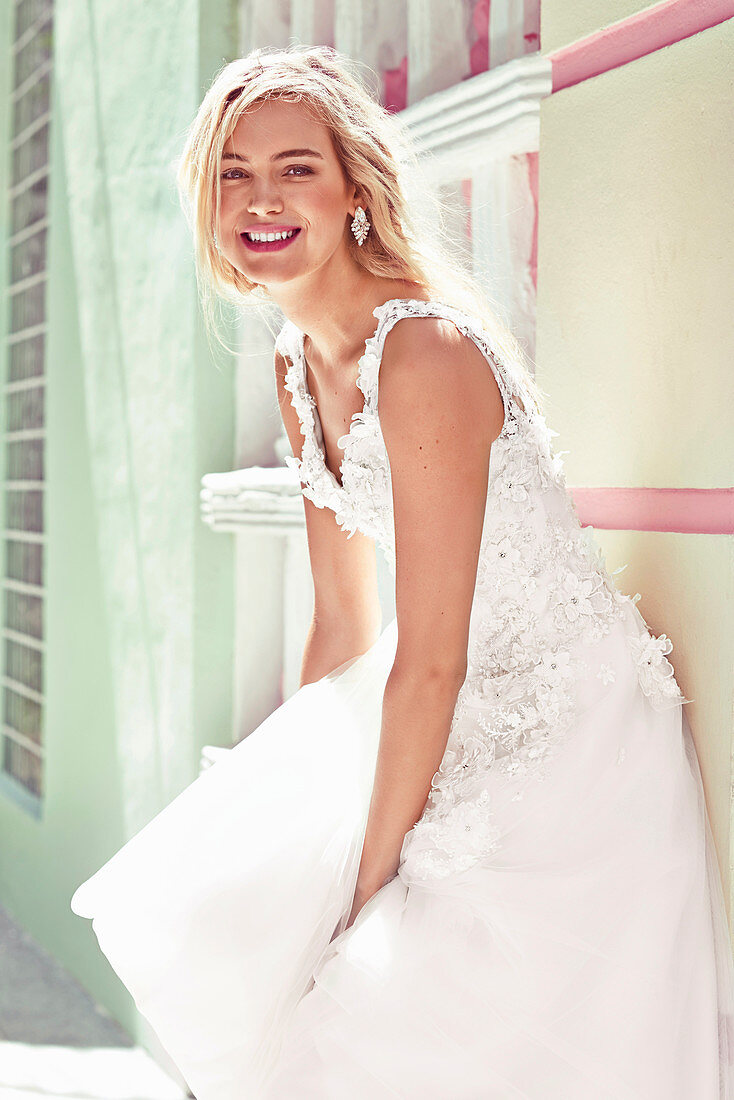 A young blonde woman wearing a white wedding dress
