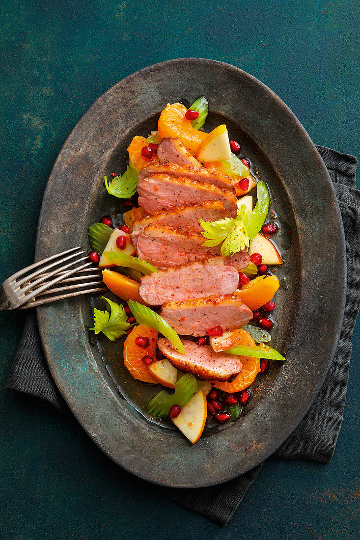 Asian duck breast with pomegranate on a tangerine and celery salad