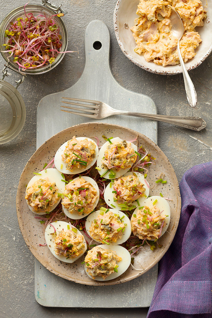 Hard-boiled eggs stuffed with ham, egg yolks and sprouts