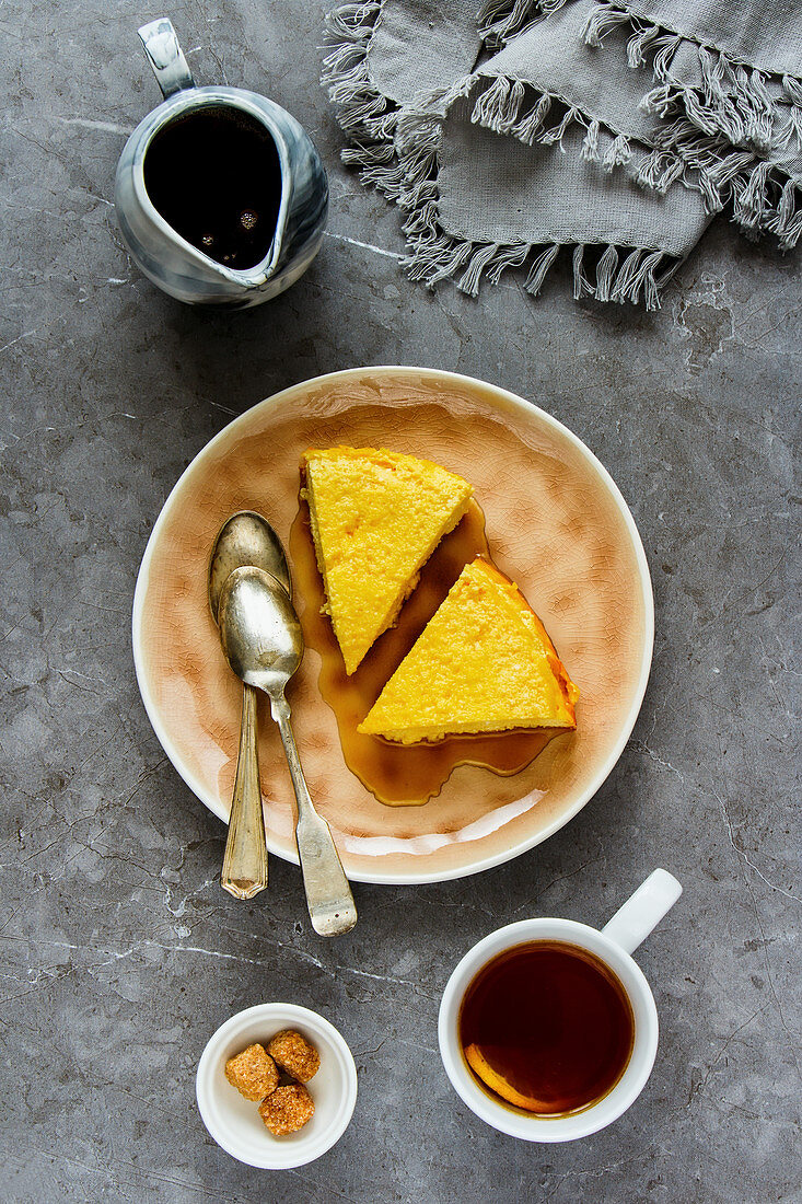 Sweet breakfast with soft homemade cottage cheese cake, maple syrup and tea cup