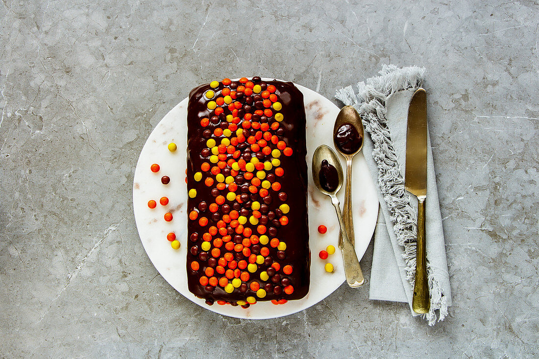 A small chocolate cake with colourful chocolate pearls