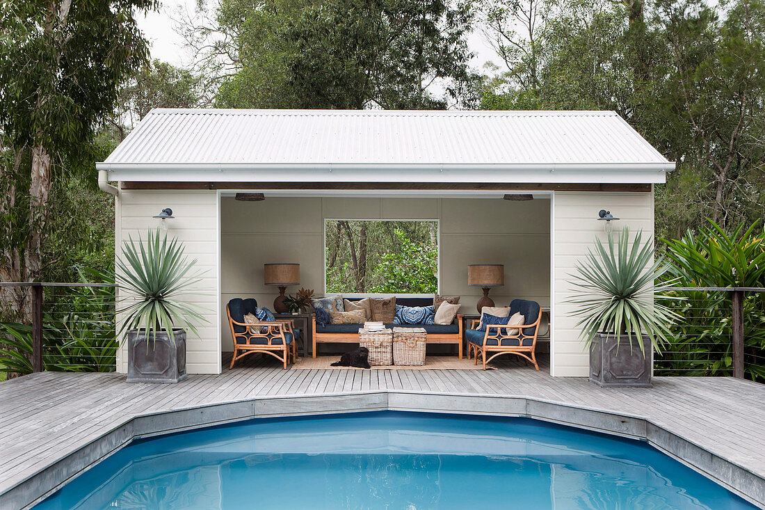 White pool house with outdoor furniture