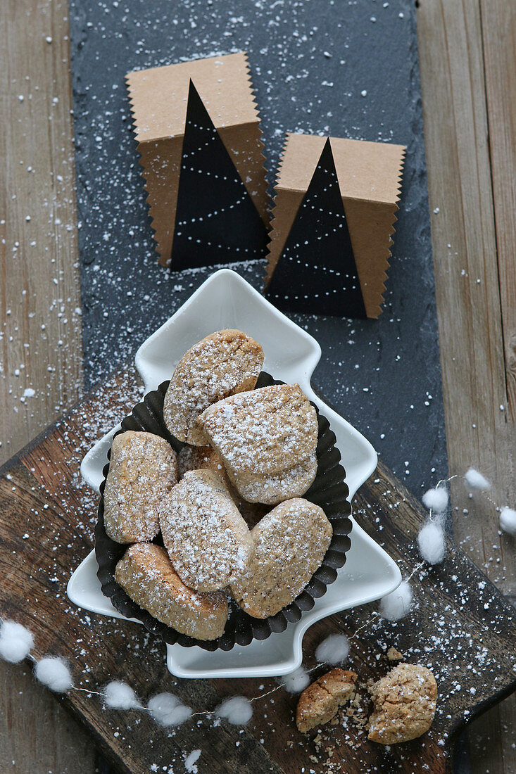 Glutenfreie Mürbeteigkekse mit Haselnüssen in Tannenbaumschale mit Weihnachtsdeko und Girlande