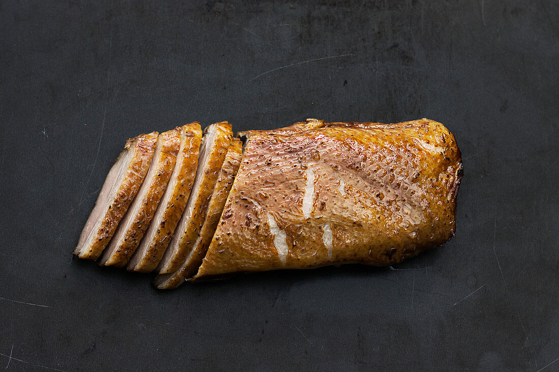 Smoked duck breast fillet on an industrial black background