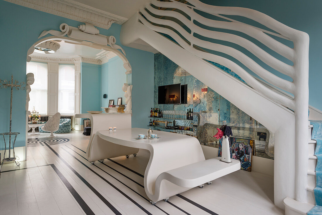 Extravagante Maisonettewohnung in himmelblau mit Designermöbeln und skulpurartigem Treppengeländer