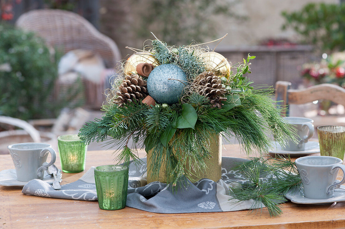 Weihnachtsstrauß in goldener Vase als Tischdekoration