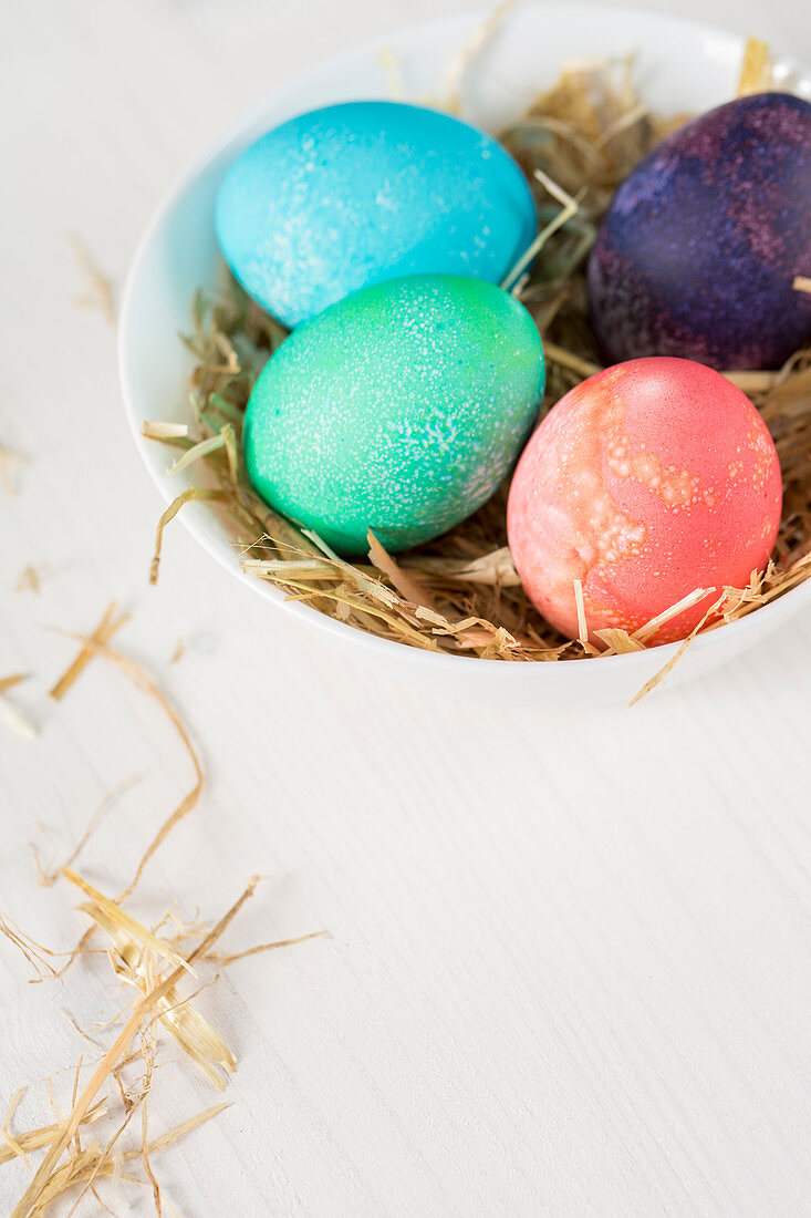 Coloured Easter eggs in a bowl of straw