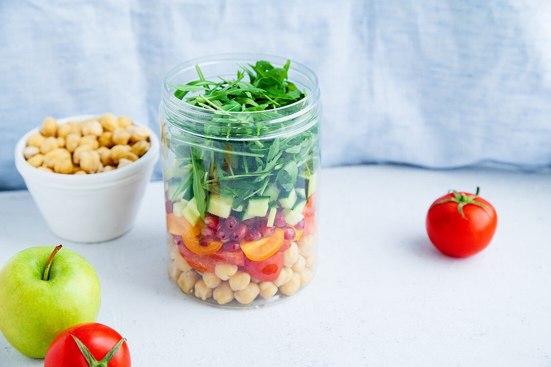 Healthy salad with chickpeas and arugula in a jar