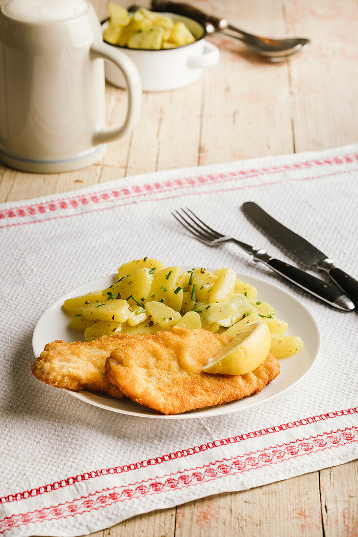 Schweineschnitzel mit Kartoffelsalat und Bierkrug