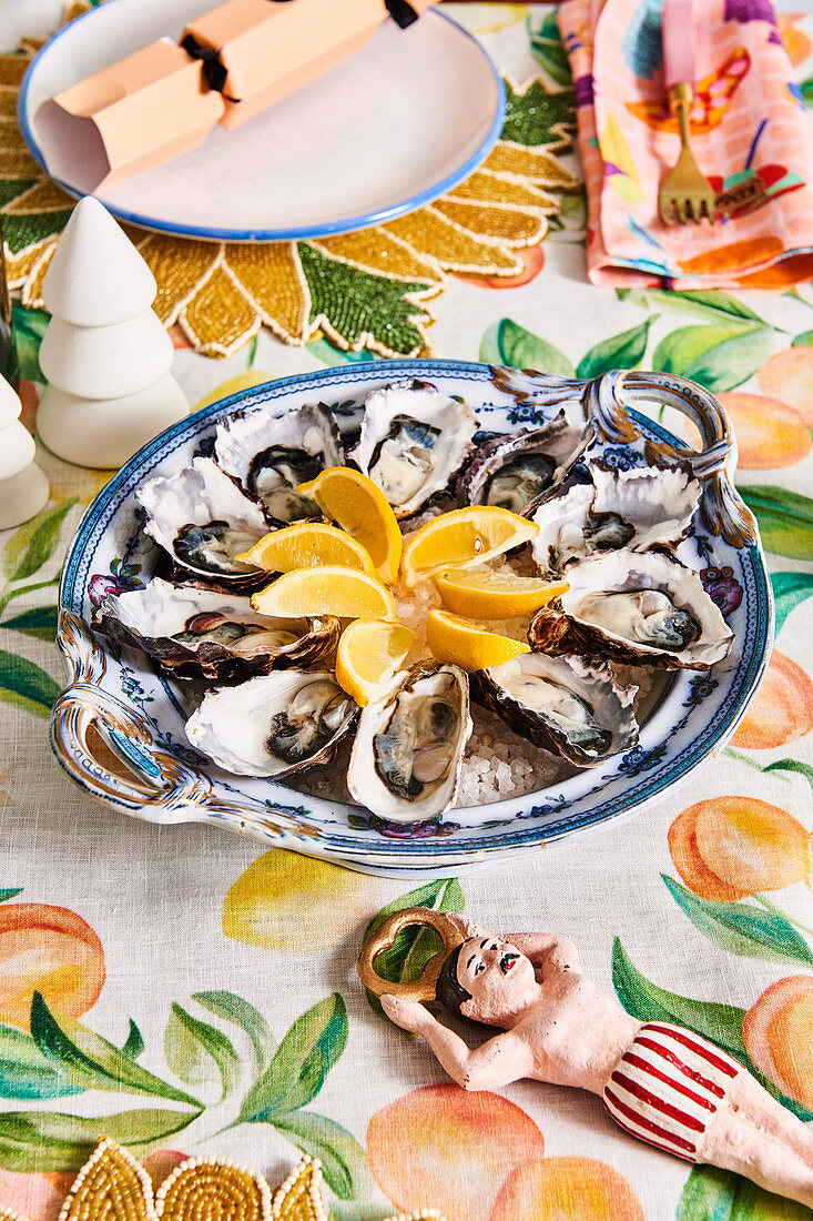 Austern mit Zitronen auf farbenfroh weihnachtlich gedecktem Tisch