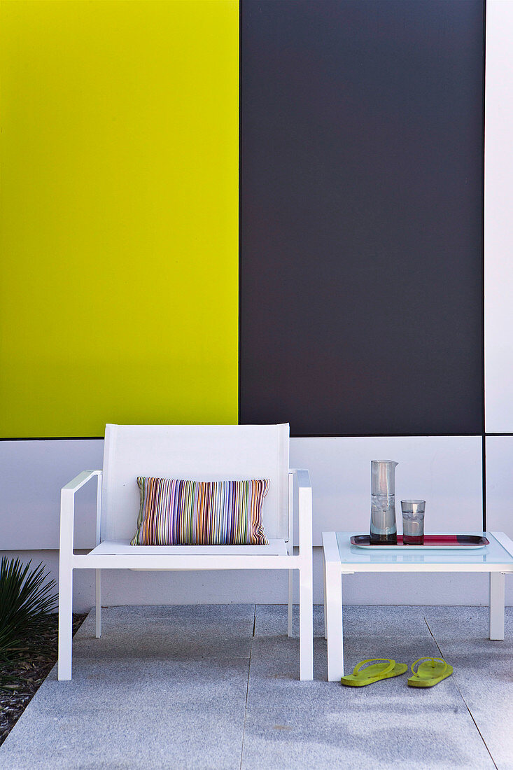 Garden furniture on the terrace in front of colorful cladding