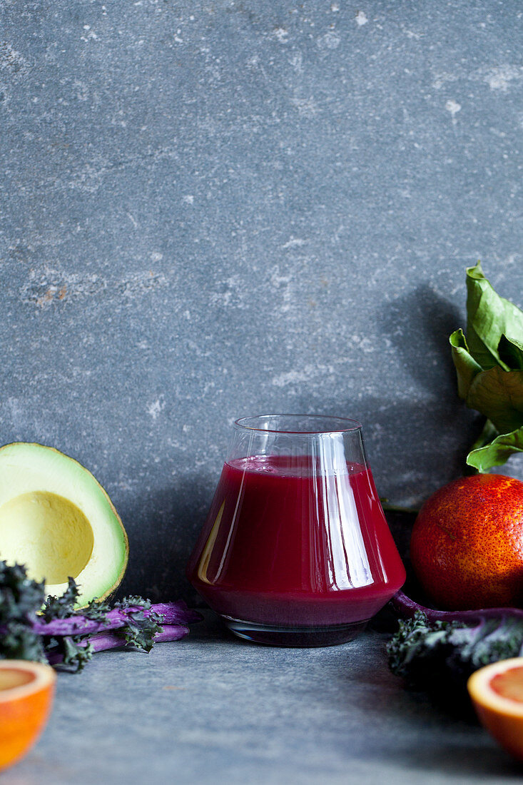 Ein Glas Rote-Bete-Saft, umgeben von Obst und Gemüse