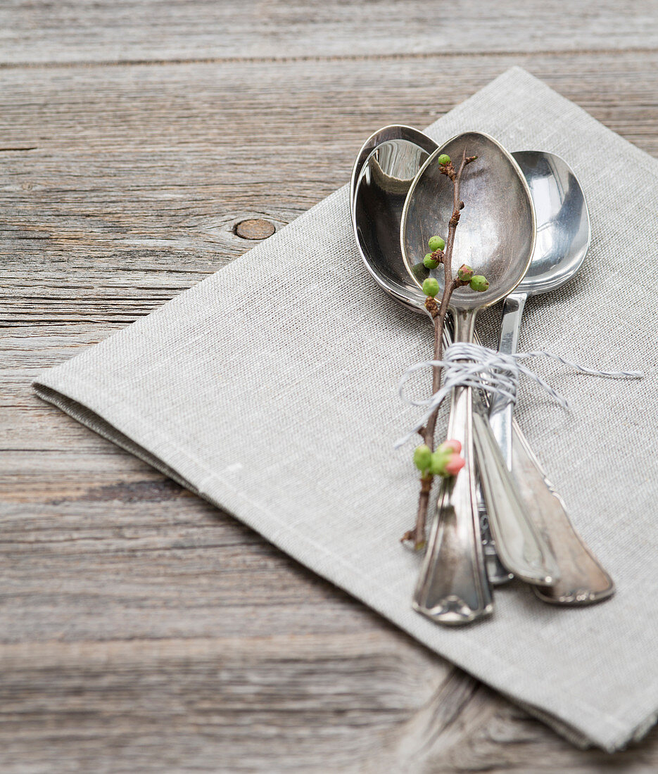 A bundle of spoons with a spring twig