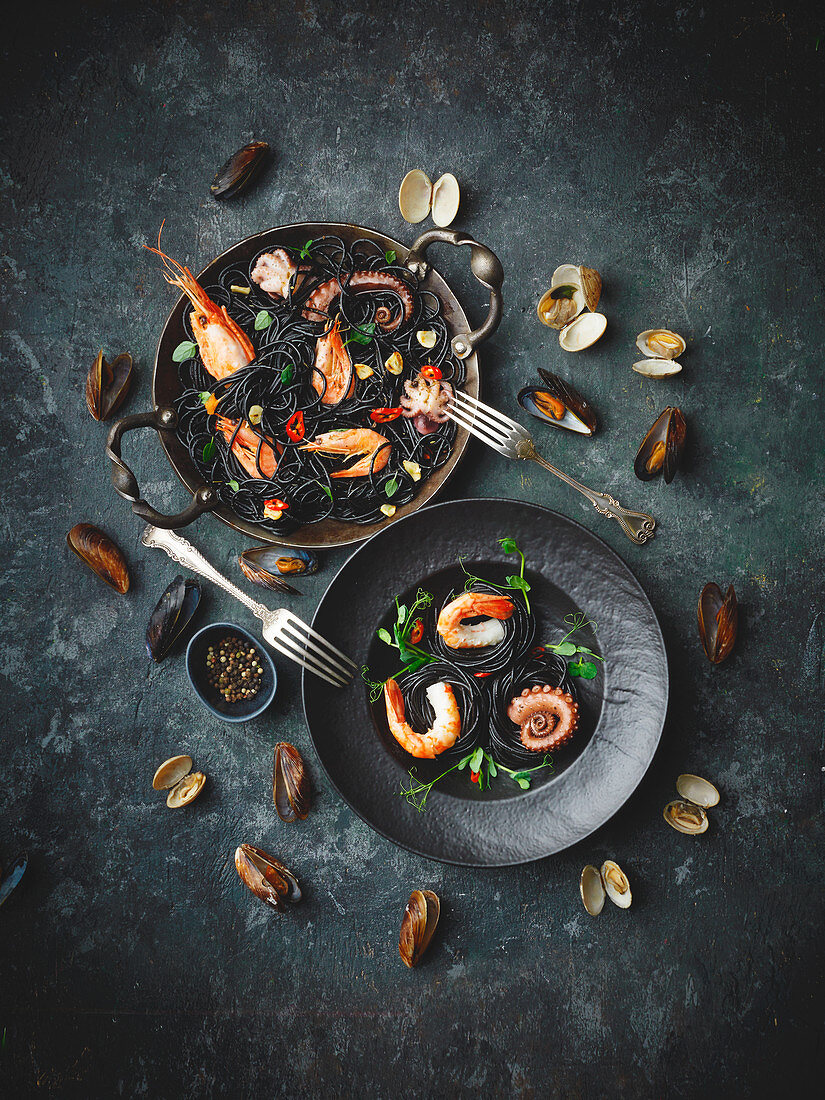 Sepia spaghetti with seafood on a black surface