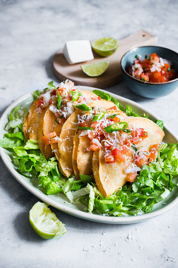 Tacos de Papa (mit Kartoffelfüllung) auf Salat mit Tomatensalsa