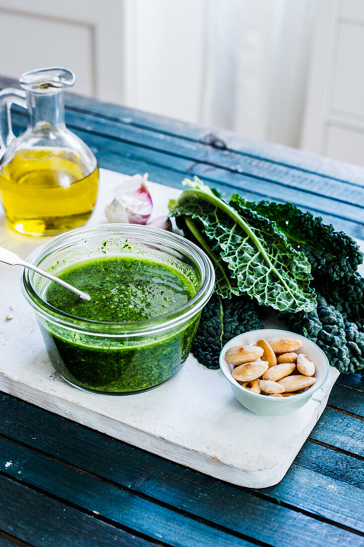 Schwarzkohlpesto im Glas und Zutaten auf Schneidebrett