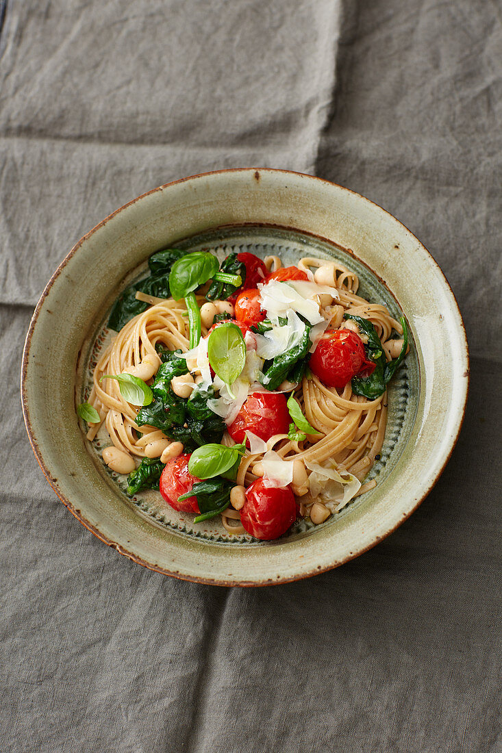 Wholemeal pasta with white beans, spinach and cherry tomatoes
