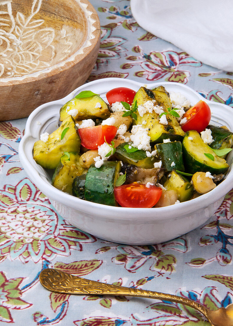 Grilled vegetable salad with feta in a white bowl